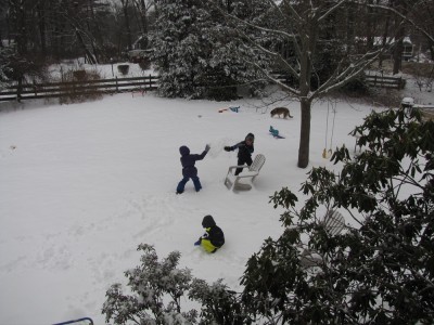 kids having a snowball fight in the snowy yard