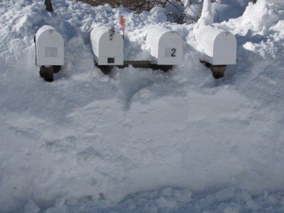 the mailboxes for our street peeking out of the side of a snowbank