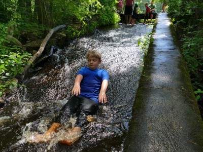 Zion sliding down a concrete spillway into a shallow pond