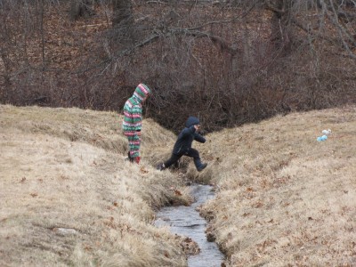 Zion jumping over a stream, Harvey waiting his turn