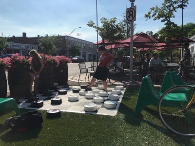 Harvey playing checkers on the giant street board in Lexington
