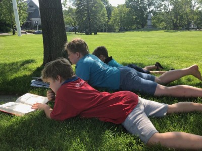 the boys reading lying in the grass of Lexington Common