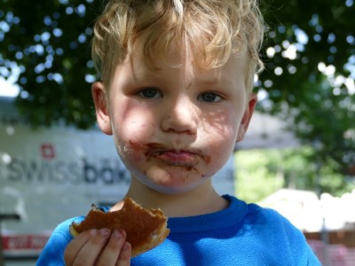 Lijah eating a chocolate donut at the farmers market