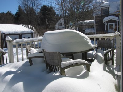 a lot of snow on the table on the back deck