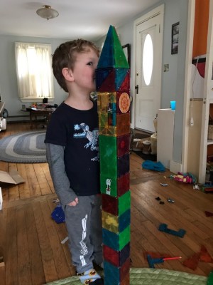 Lijah measuring himself against a Magnetiles building