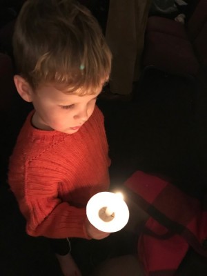 Elijah holding a candle in church on Christmas Eve