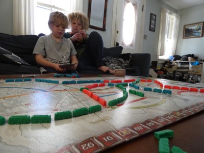 Harvey and Zion looking at the Ticket To Ride board on the coffee table