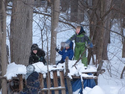 Harvey and Zion having a snow fight with friends atop the tree house platform