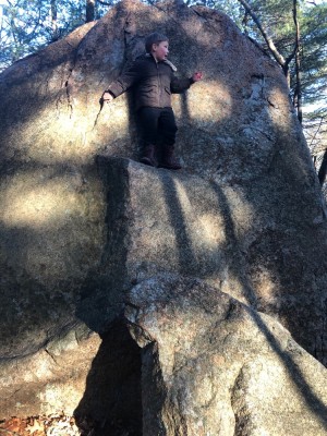Elijah standing on a ledge halfway up a big rock