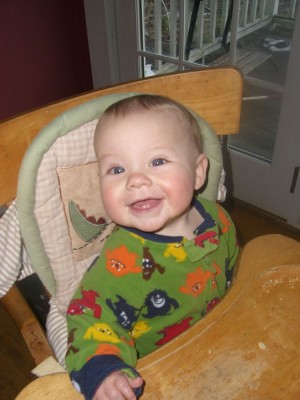 zion smiling in the high chair