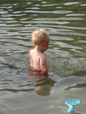 Lijah walking by himself in the pond, with water above his waist