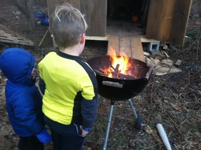 Zion (in his winter coat) and Harvey (not) keeping warm by a fire in the grill
