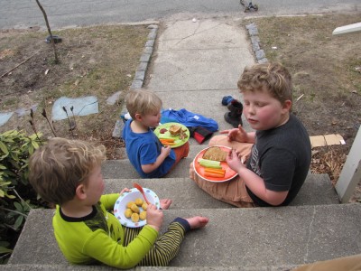 the boys having lunch on the front steps, wearing shorts