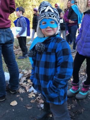Zion in a mask and cape at Emily's birthday party