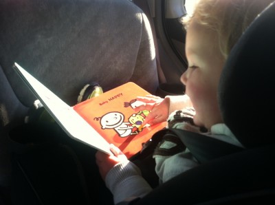 Lijah reading in his car seat