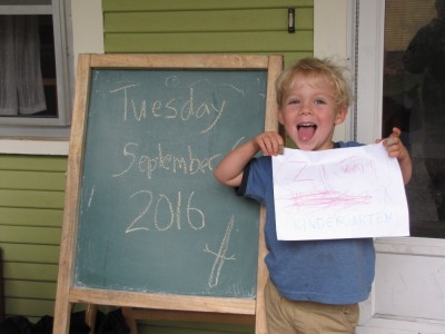 Zion looking energetic holding his kindergarten sign