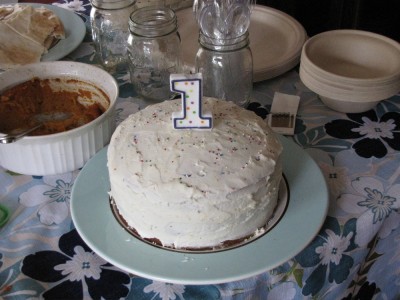 the cake: white with colored sprinkles and a candle in the shape of a 1